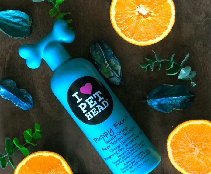 A bottle of Pet Head Puppy Fun next to some orange slices